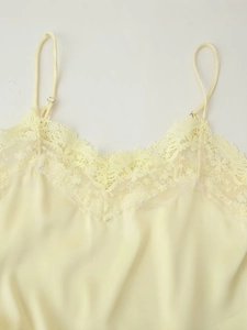 Gros plan sur la dentelle délicate et les fines bretelles d'un caraco soyeux jaune
