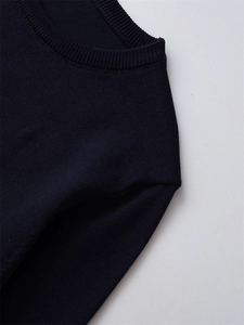 Detailed view of the crew neckline and premium knit texture on navy blue sweater