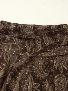 Detailed macro view of brown paisley pattern on lightweight sheer chiffon fabric