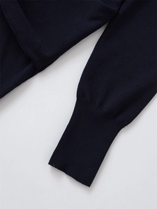 Detail of navy blue knit sweater featuring premium long ribbed cuffs and fine texture