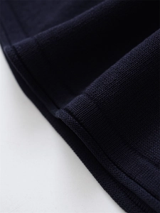Close-up of the navy blue knit fabric texture and high-quality edge detailing