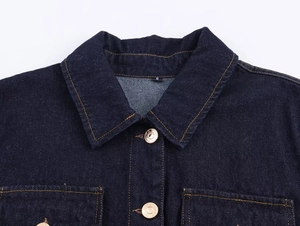 Close-up of dark blue denim jacket collar with metal buttons and yellow stitching
