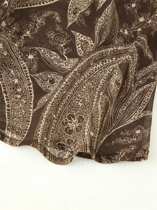 Close-up of deep brown paisley pattern on lightweight sheer mesh long skirt fabric