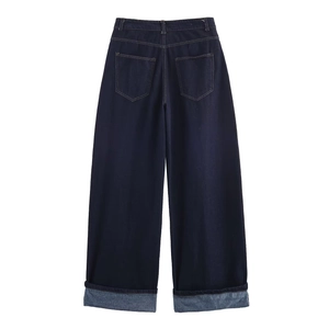 Detail of high-waisted dark blue wide-leg denim jeans with back pockets and cuffed hems