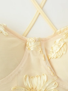 Detailaufnahme des cremefarbenen Netzkleides mit floraler Stickerei und feinen Trägern