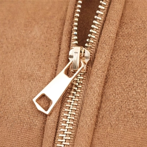 Détail de la fermeture éclair en métal doré sur une veste marron pour femme