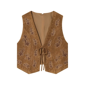 Detail of vintage floral embroidery on brown faux suede vest with front lace-up tie