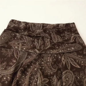 Elegant dark brown paisley print maxi skirt with pleated waist and flowy fabric detail