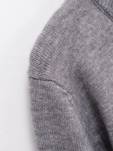 Detail shot of the shoulder seam and fine knitting craftsmanship of the grey cardigan