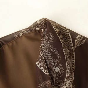 Deep brown floral print skirt detail with elegant white patterns and fine stitching