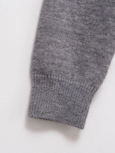 Detail of grey knitted cardigan cuff showing high-quality rib-knit texture and soft wool blend