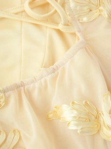 Detail der zarten 3D-Bandstickerei und Netzschichten an diesem eleganten beigen Kleid