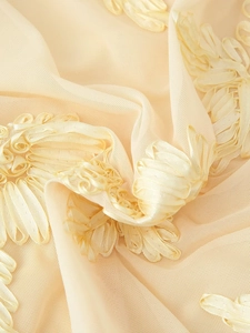 Detailaufnahme von hellgelbem Netzstoff mit 3D-Bandstickerei für elegante Maxikleider