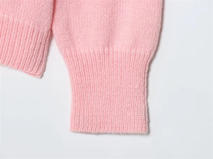 Close-up of soft pink mohair knit sweater featuring ribbed cuffs and fuzzy texture