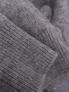 Macro detail of high-quality grey knit fabric showing soft texture and ribbed cuffs