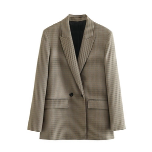 Macro detail of houndstooth plaid blazer featuring peak lapels and double-breasted buttons
