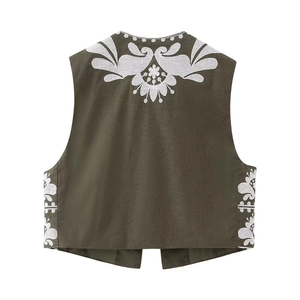 Detailed white floral embroidery on the back of a vintage olive green sleeveless vest