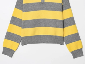 Detail of yellow and grey striped knit sweater with ribbed cuffs and polo collar texture