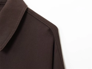 Close-up of lapel and shoulder stitching on a dark brown casual jacket with fine texture