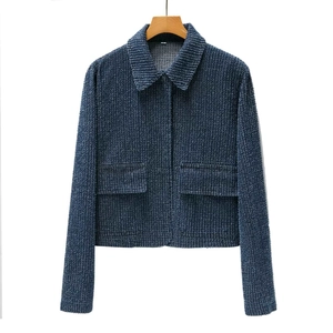 Detail view of the textured blue tweed fabric and flap pockets on the women's jacket