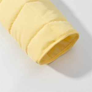 Detail of quilted light yellow padded jacket sleeve with smooth finish and stitching
