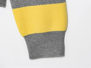 Detail of knit polo shirt cuff with grey and yellow stripes and ribbed texture