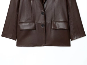 Détails du blazer en cuir marron foncé montrant la texture, les revers et les boutons