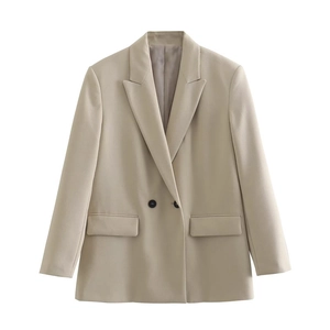 Detail shot of beige casual blazer featuring peak lapels and black contrast buttons