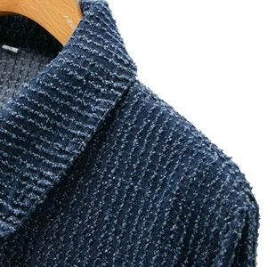 Detailed macro view of dark blue textured tweed jacket collar with size S label
