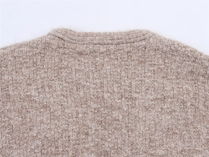Nahaufnahme des Strickpullover-Ausschnitts in Haferflocken-Beige mit grober Textur
