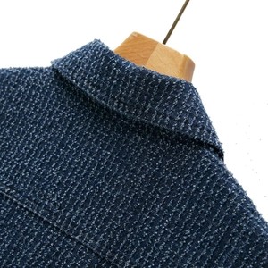 Close-up of blue and white textured tweed denim jacket lapel with woven fiber detail