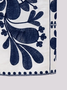 Detailed close-up of navy floral embroidery on white ethnic style vest fabric