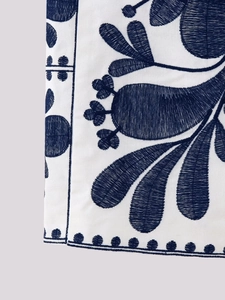 Close-up of blue and white floral embroidery on a high-quality cotton linen vest