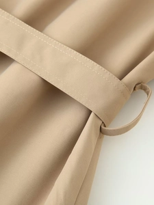 Detail of khaki trench coat waist belt with stitching and fine twill fabric texture