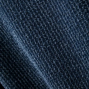 Close-up detail of dark blue twill denim fabric texture with thick fiber weave