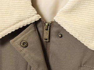 Détail du col en velours côtelé et des boutons-pression vintage de la veste