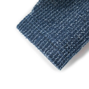 Macro shot of dark blue textured denim fabric showing detailed woven fiber quality