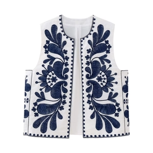 Boho chic white sleeveless vest featuring navy blue floral embroidery and open front design