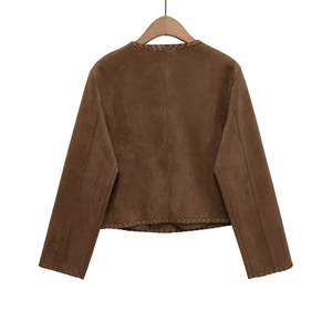 Detail view of brown suede jacket back featuring handcrafted whipstitch edges on a hanger