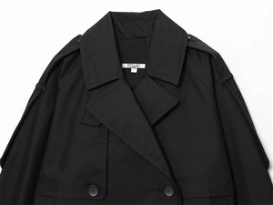 Detail of water-resistant black trench coat featuring collar lapels and shoulder epaulets