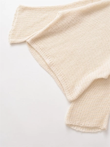 Detailed close-up of hollow knit texture on a loose cream white mohair blend sweater