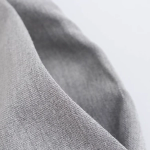 Vista macro de tela textil gris medio con textura suave y estructura de tejido fino