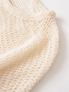 Detailed macro view of the cream loose-knit sweater neckline and mohair texture