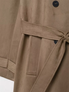 Detail eines khakifarbenen Wildleder-Trenchcoats mit Gürtel und braunen Knöpfen