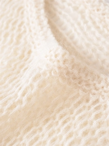 Close-up of cream knit sweater showing soft mohair texture and loose weave structure