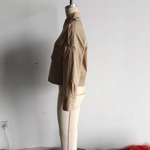 Détail de profil d'une veste courte kaki avec pattes d'épaule et grandes poches latérales