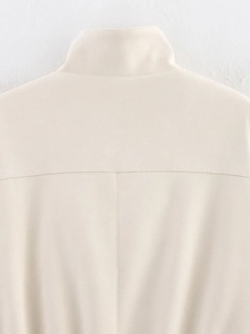 Gros plan d'une veste beige effet daim montrant le col montant et les coutures