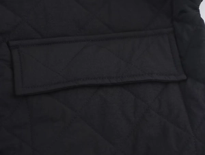 Close-up of black quilted jacket featuring diamond stitching and reinforced pocket flap detail