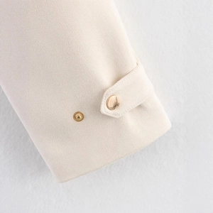 Veste chic en velours crème à col montant avec boutons dorés sur les manches