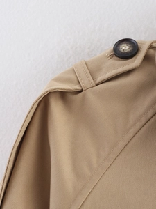 Détail de la patte d'épaule avec bouton et texture sergée du trench-coat couleur kaki